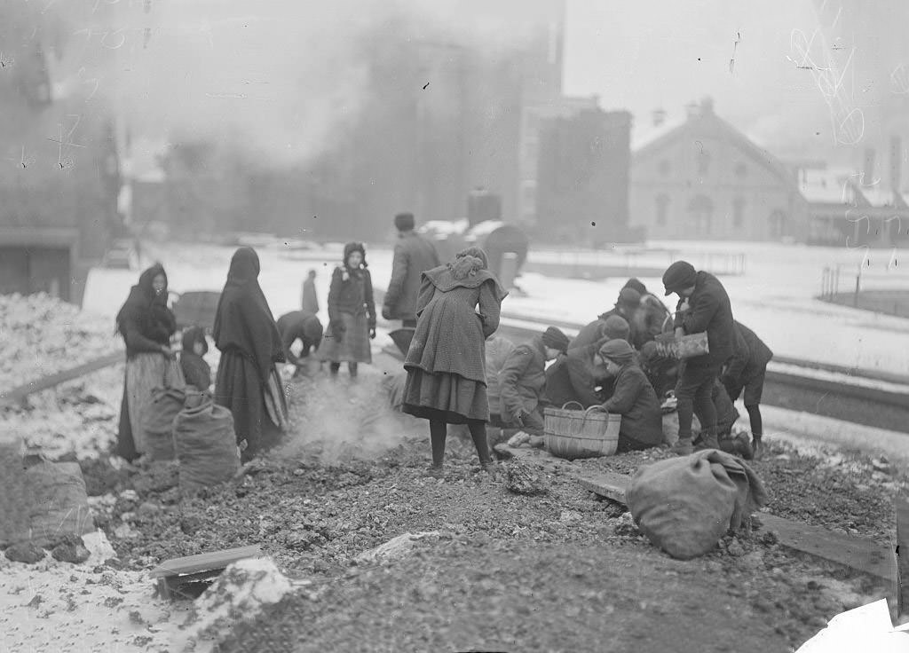 #41 Women and children picking up coal from the ground at the coal yards during winter, Chicago, Illinois, 1902.