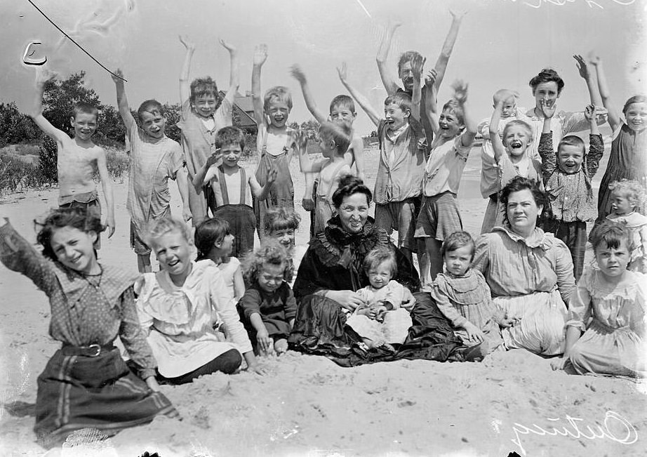 #170 Women and children sitting on a sandy beach while on a Chicago Daily News Fresh-air outing in Chicago, Illinois, 1902.