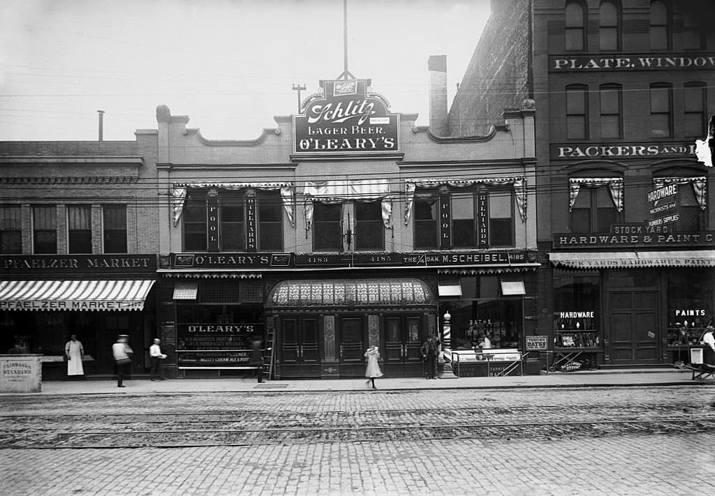 #187 Exterior view of O’Leary’s saloon with neighboring buildings partially visible and merchants and pedestrians on the sidewalk, Chicago, 1906.
