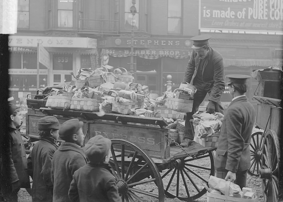 #213 Salvation Army distributing turkeys, Salvation Army volunteers unloading Christmas food baskets from a wagon, 1900s.