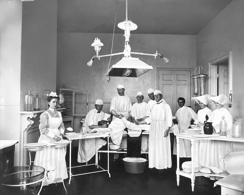#23 Operating room in a Mobile, Alabama, 1900s. The doctors and nurses pose before operating on a patient.
