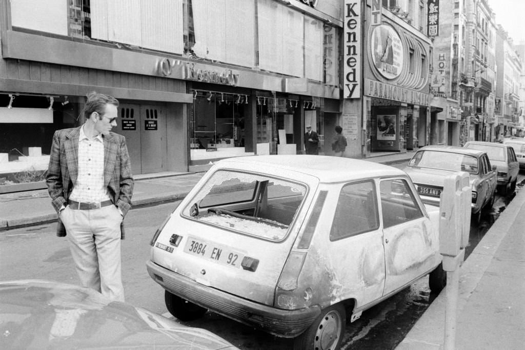 #189 A passer-by looks at a burnt-out car following a violent demonstration during the trial of 16 Basque nationalists in Burgos, Spain, September 28, 1975.