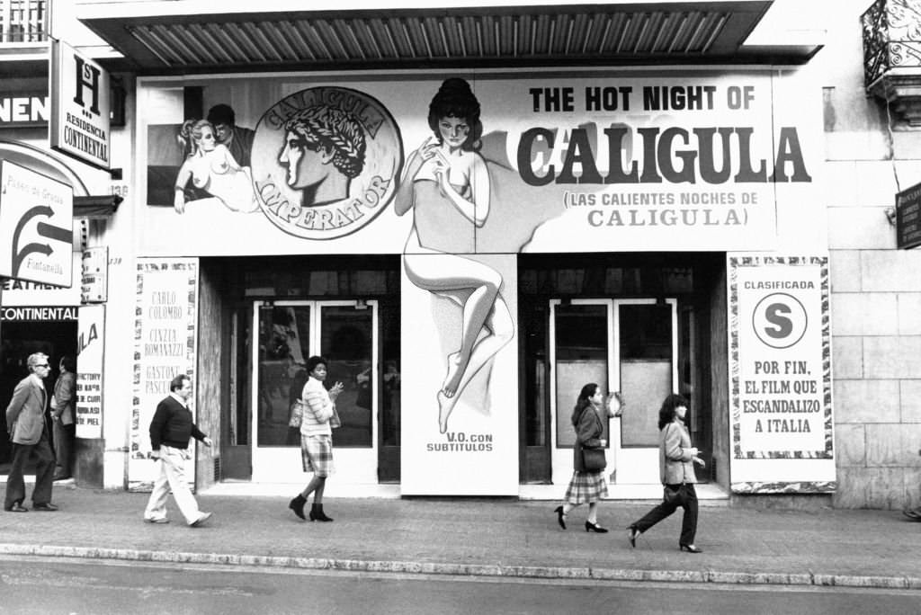 #131 Poster of the erotic film ‘The Crazy Nights of Caligula’ in front of a cinema on La Rambla, in Barcelona, Spain, on November 25, 1982.