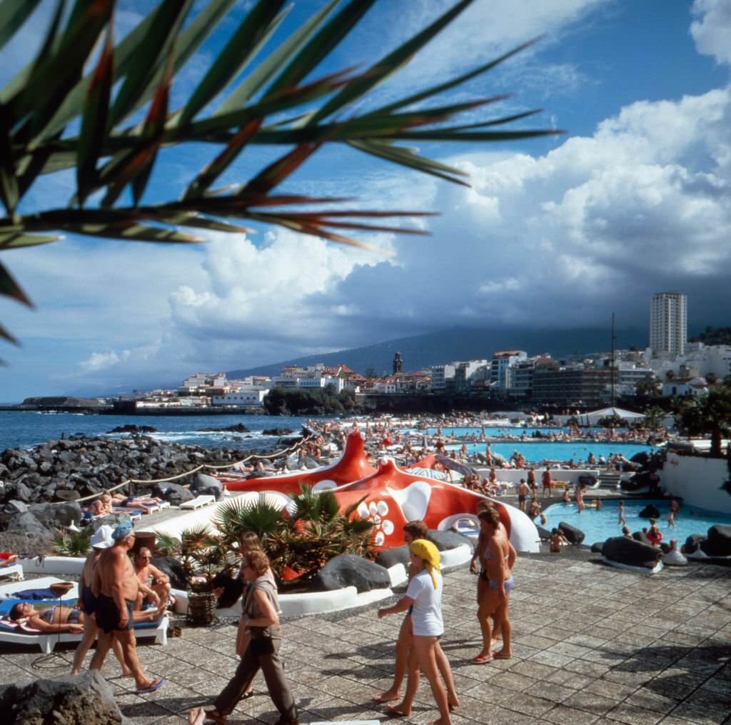 #81 Tourists at sea swimming pools at Puerto de la Cruz on Tenerife, Spain 1980s.