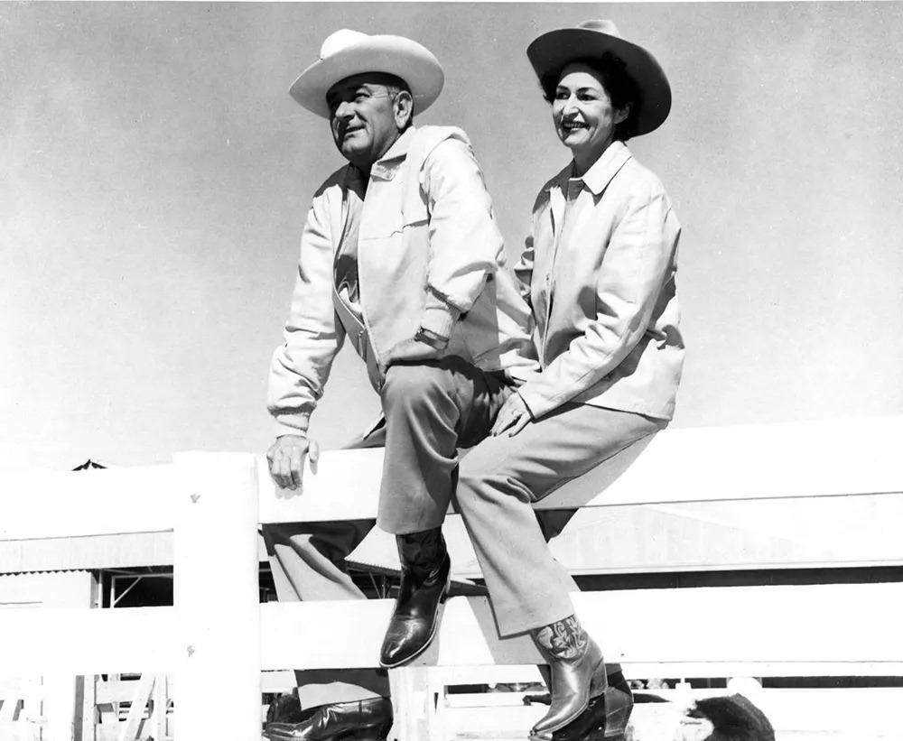 #11 Lyndon B. Johnson and his wife Lady Bird sit on a fence at their ranch in Texas, 1963.