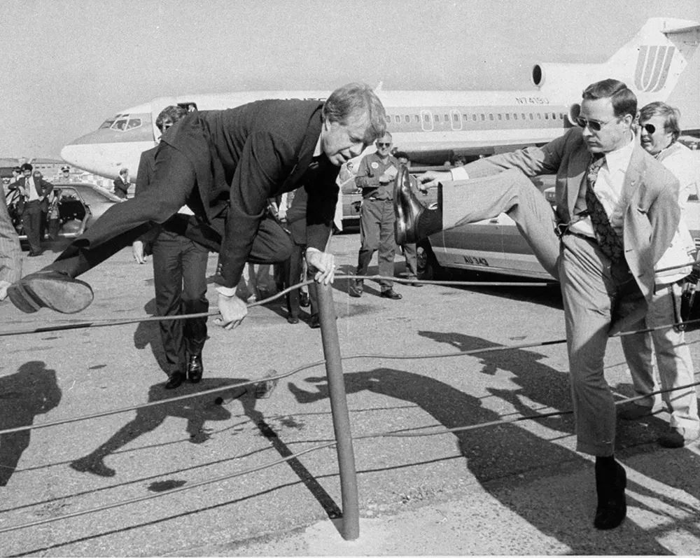 #14 Jimmy Carter and an aide hop a fence at LaGuardia airport in New York City, 1976.