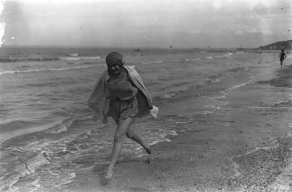 #10 A young woman running along the water’s edge at Deauville, 1924