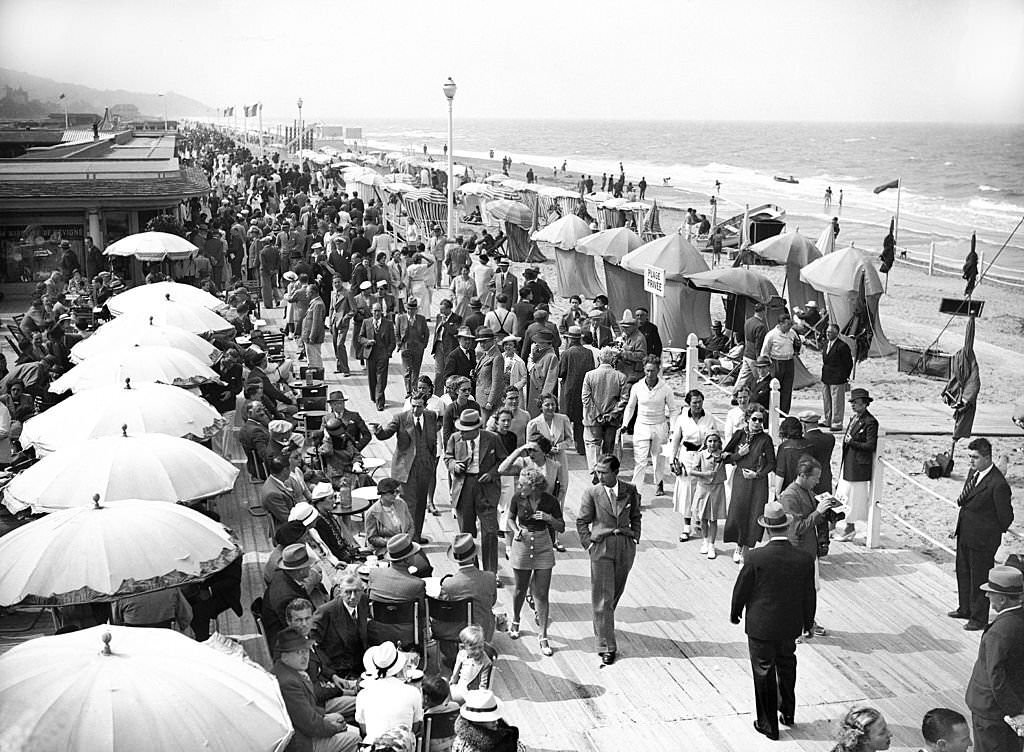 #144 Vacationers on the beach and in front of the sea at Deauville, 1937
