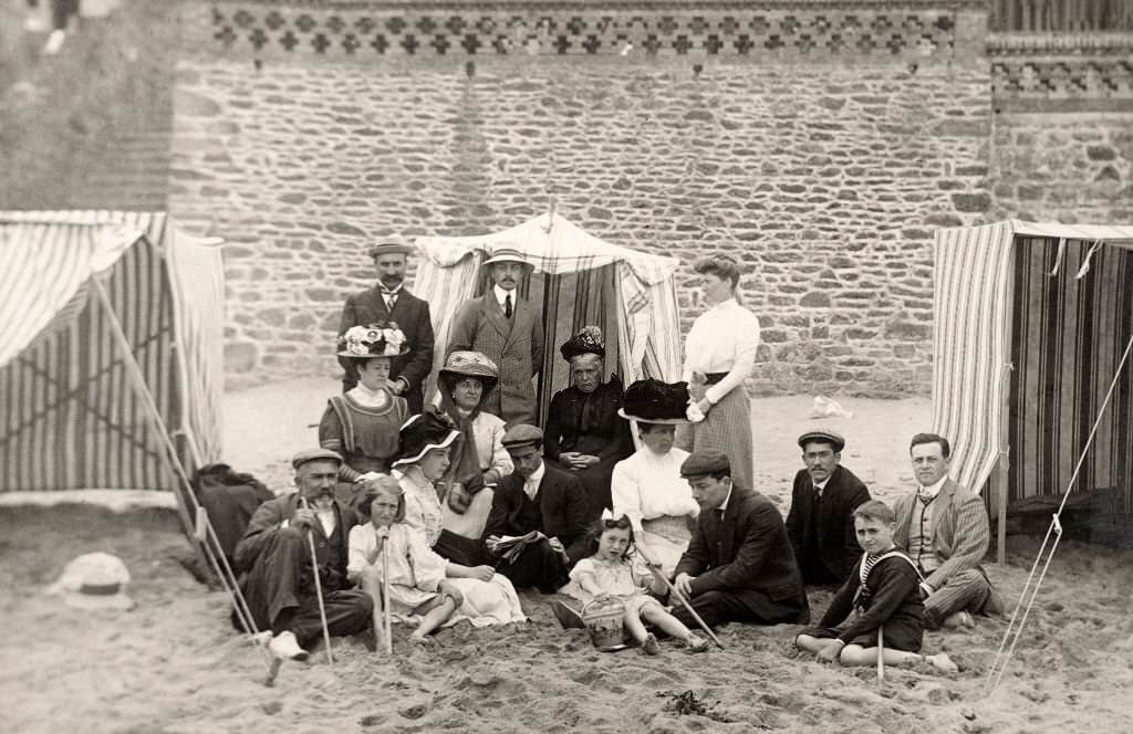 #47 A family group wearing their Sunday best sitting on the sand at a beach at Deauville, 1910