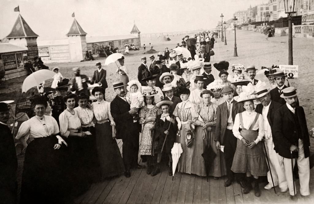 #48 A large group of people wearing the latest fashion on the promenade at at Deauville, 1910