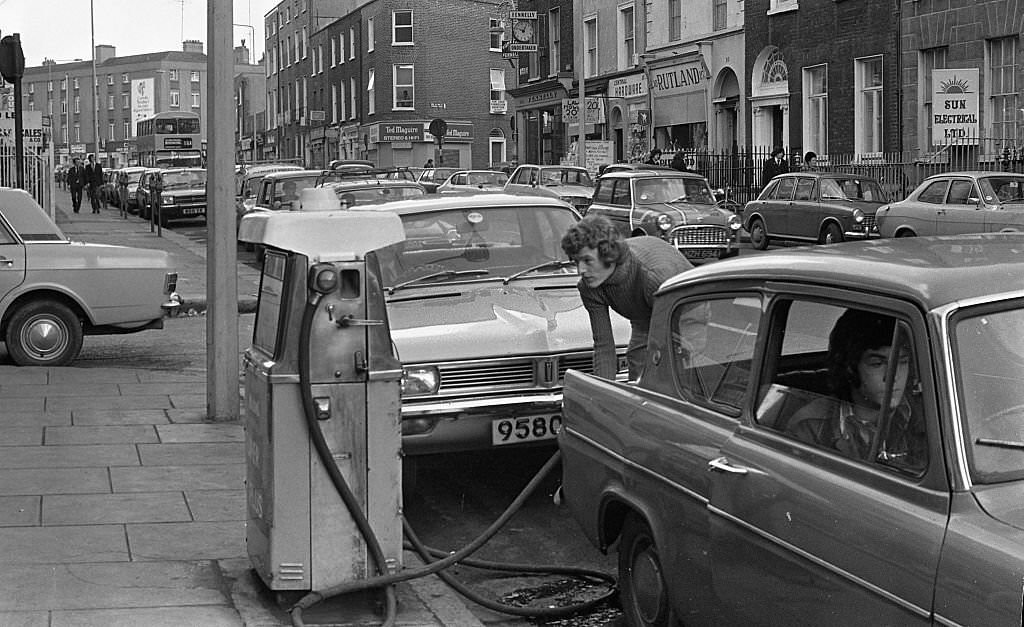 #102 Street scene, people queuing for petrol, Dublin, 1975