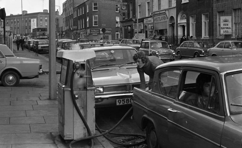 #18 A young man filling up his car from a street petrol pump, April 1975.