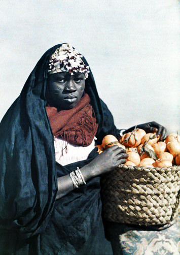 #26 Woman posing with a basket of mandarins or tangerines.