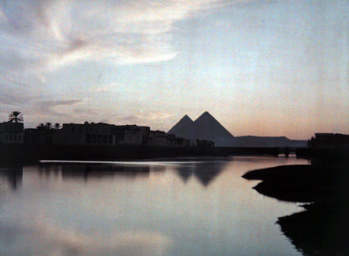 #28 View of the pyramids with buildings in between.