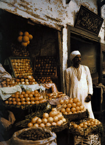 #34 Orange merchant awaits customers.