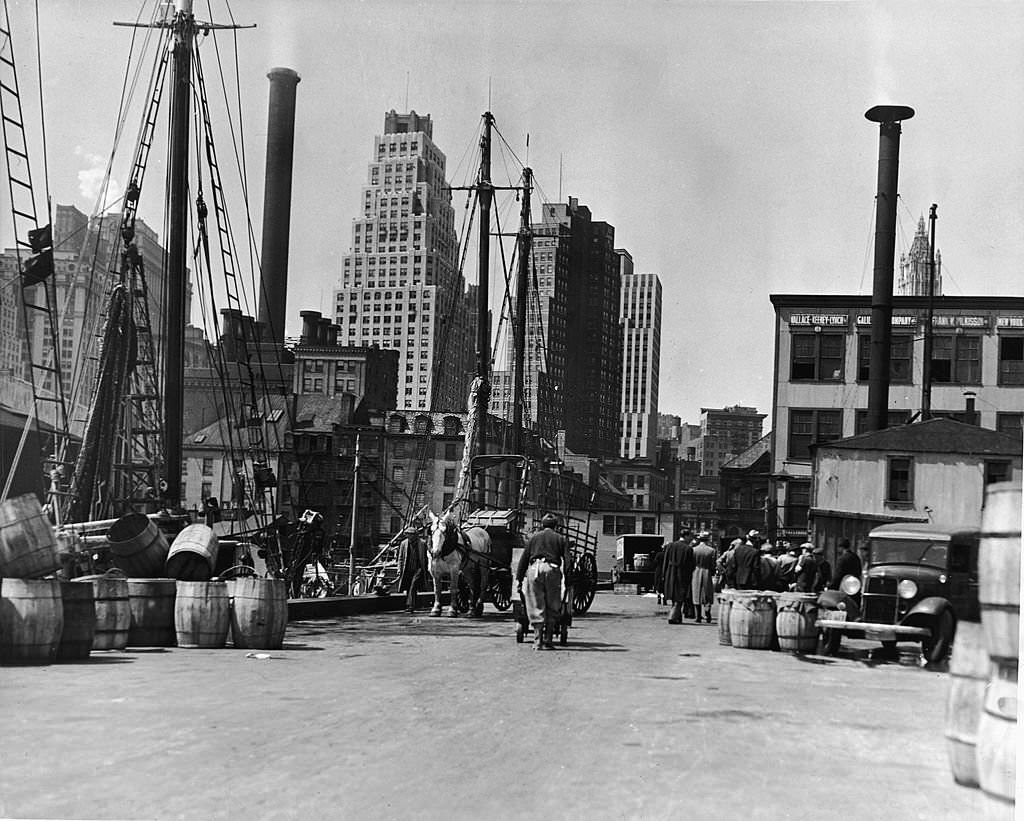 #108 View of the East River docks, New York, New York, 1930s. The masts of several docked fishing boats are visible at left.