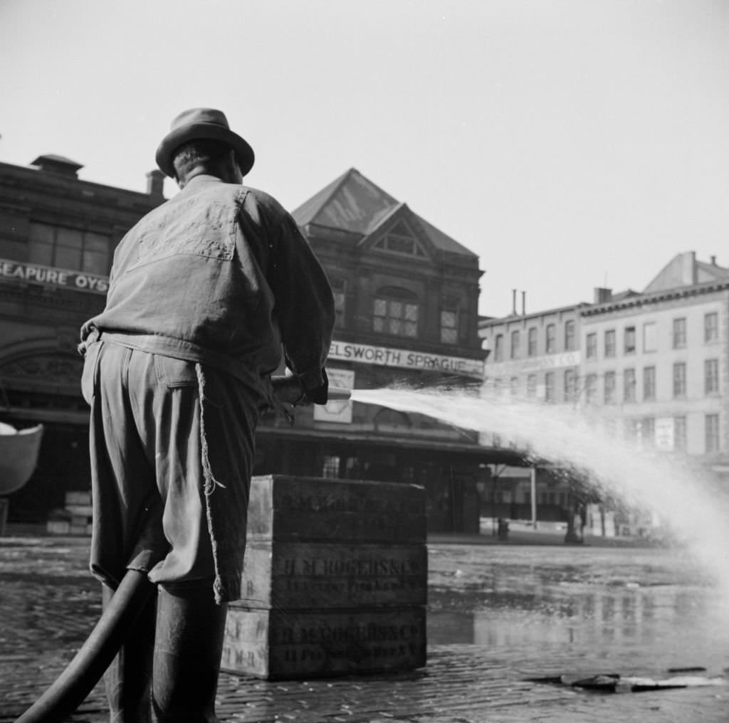 #6 Workmen from the sanitary department flushing the street in front of the Fulton fish market late in the evening. Artist Gordon Parks, 1930s