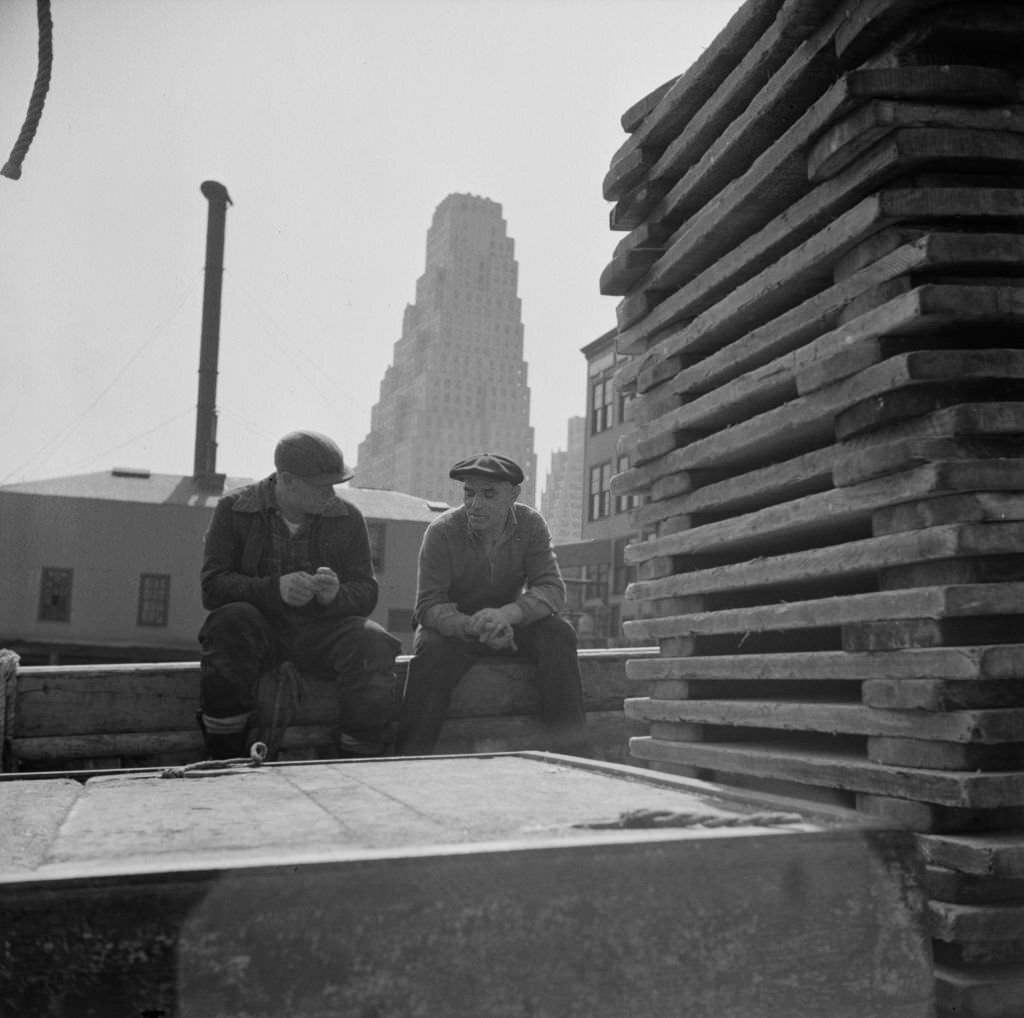 #9 Gloucester fishermen resting on their boat at the Fulton fish market, 1930s