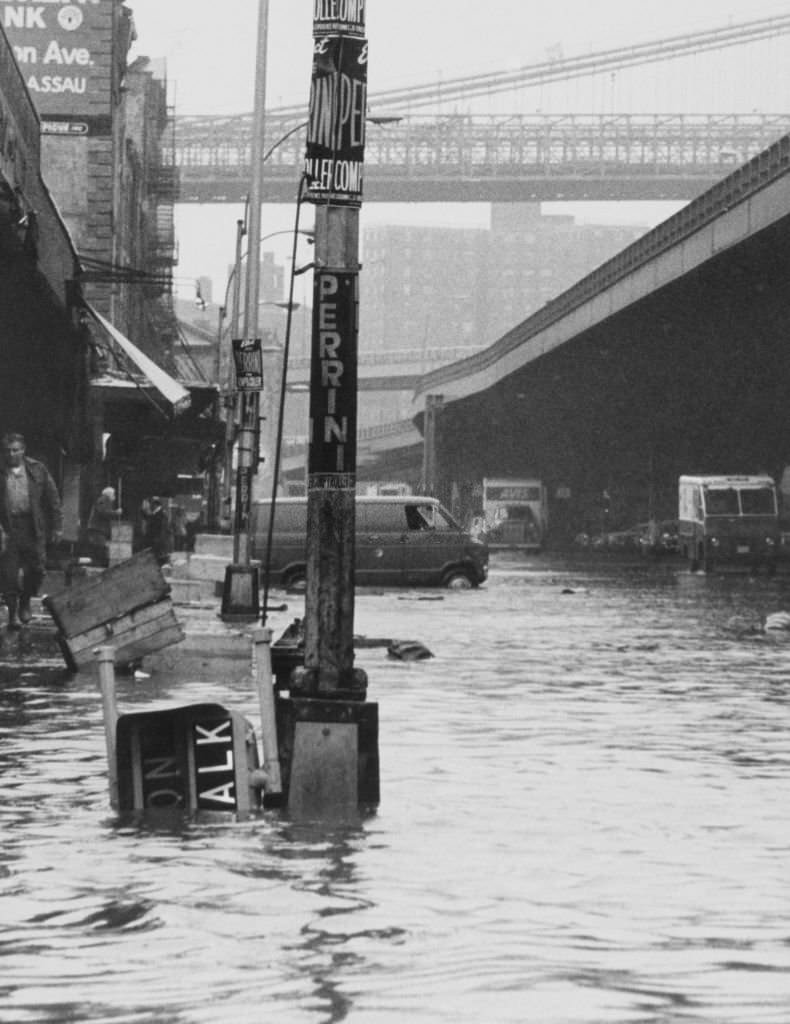 #3 Pedestrians at the Fulton Street Fish Market look as if they need a bridge after heavy wind whipped rains hit the metropolitan area, 1930s