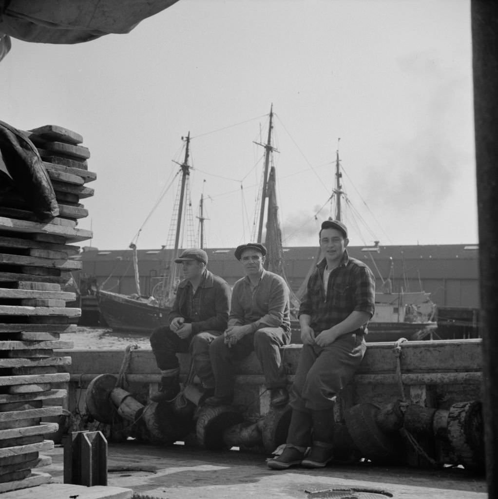 #10 Gloucester fishermen resting on their boat at the Fulton fish market, 1930s