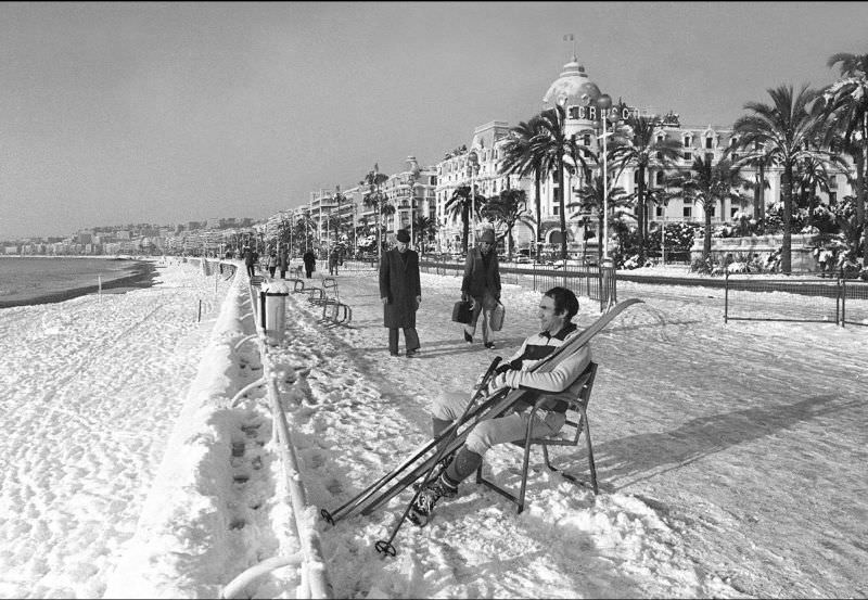 #28 A man takes off his skis to rest at the Promenade des Anglais after rare heavy snowfall in Nice, France, January 1985.