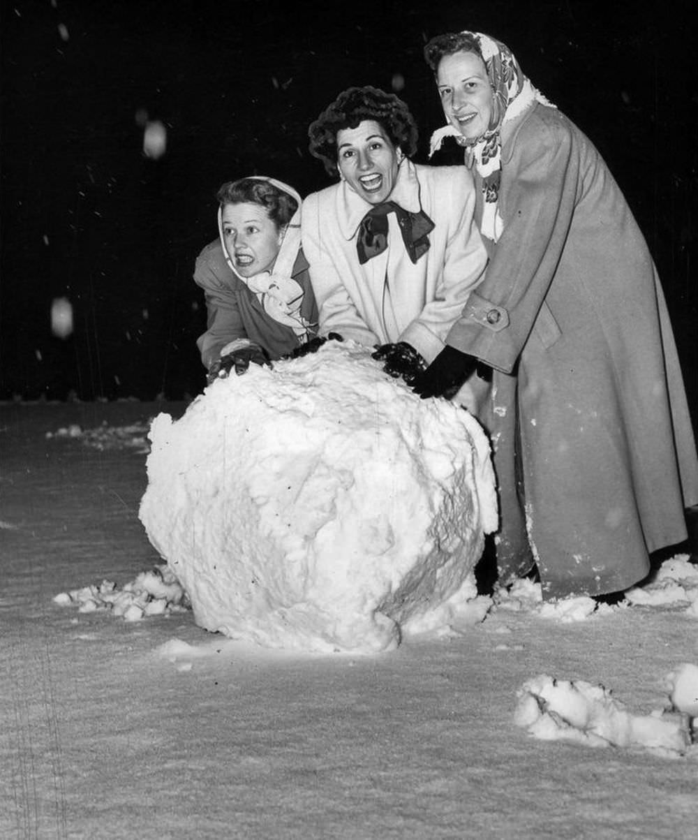#5 Women rolling a giant snowball in a front yard in Bel-Air.