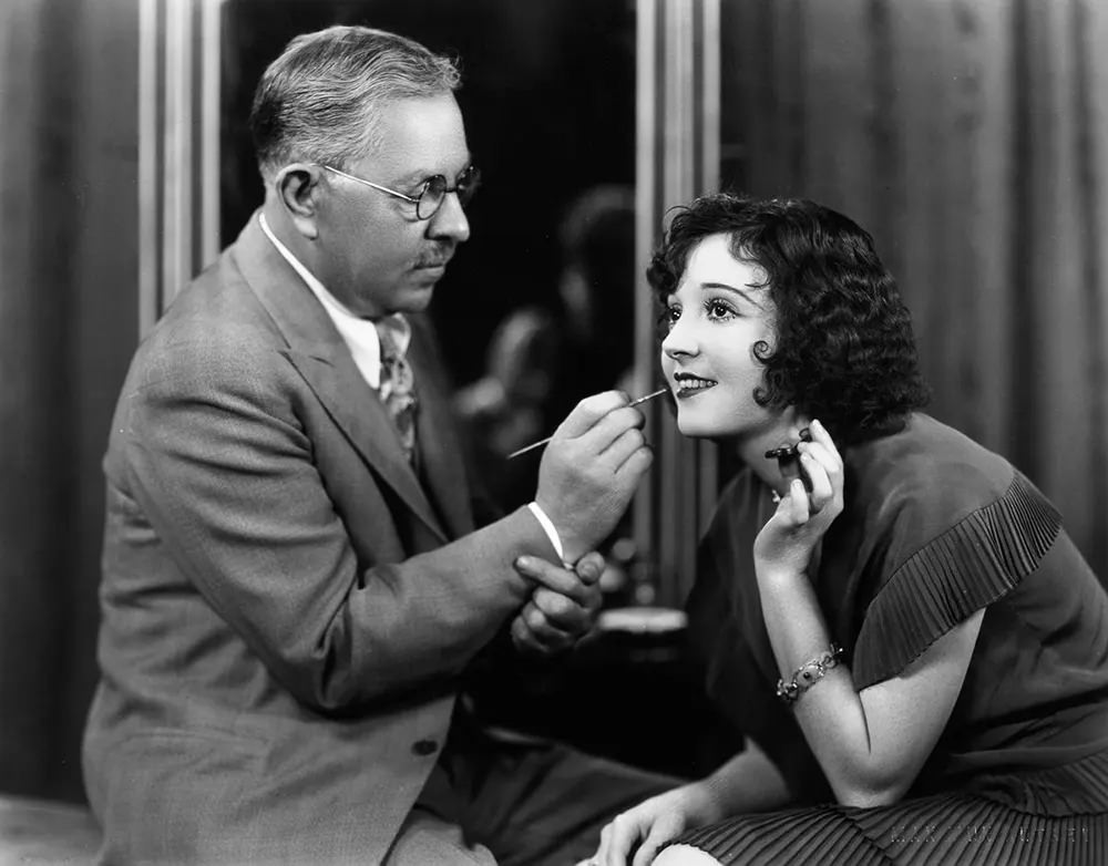 #11 Factor applies lipstick to silent film star Madge Bellamy. 1930.