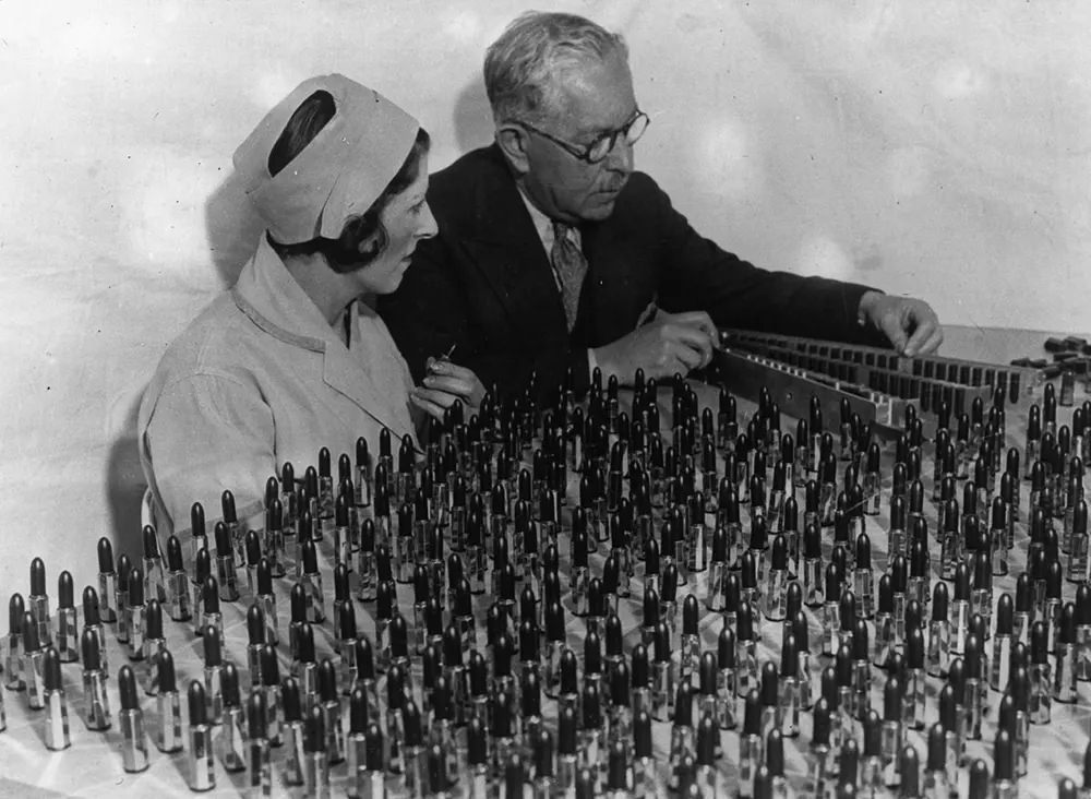 #13 Factor and Ray Judd look over an array of lipstick shades. 1932.