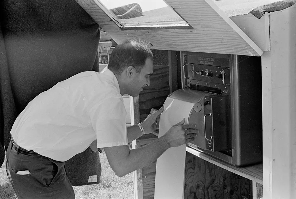 #13 A scientist checks a seismograph at an observation point.