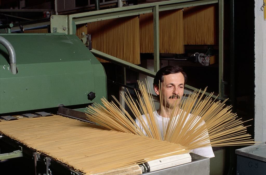 #29 A man examines spaghetti at the Buitoni pasta factory in Sansepolchro, Italy.