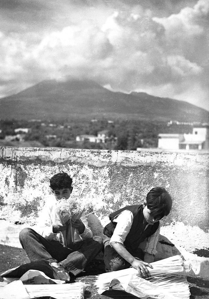 #58 Spaghetti production Two boys packing spaghetti; in the background Mount Vesuvius, 1932