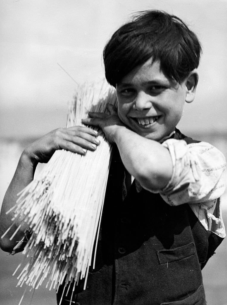 #61 Neapolitan boy carrying a bundle of spaghetti on his shoulder, 1932