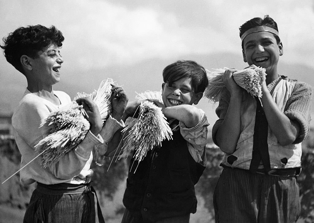 #63 Three Neapolitan boys carrying a bundle of spaghetti, 1932