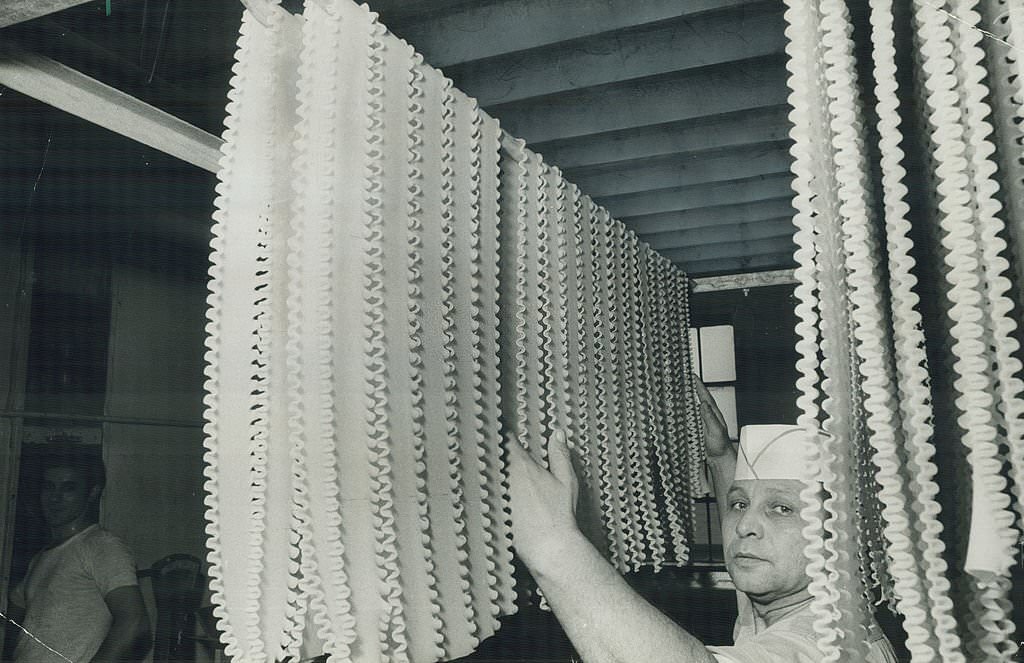#21 Lasagna noodles Pietro La Franco puts on a drying rack in a Toronto factory, 1970s