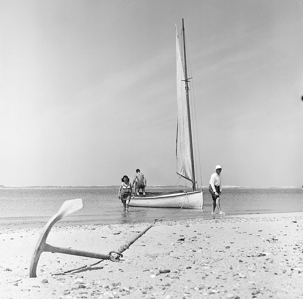 #15 A sailboat sits at anchor on the beach as two men and a woman start to debark on Cape Cod, Provincetown, Massachussetts, 1947.