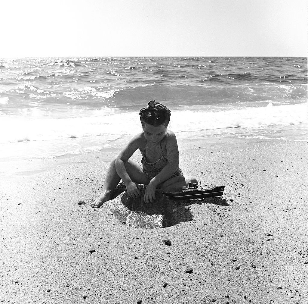 #126 A young girl plays in the sand at the beach, Provincetown, Massachusetts, 1948.