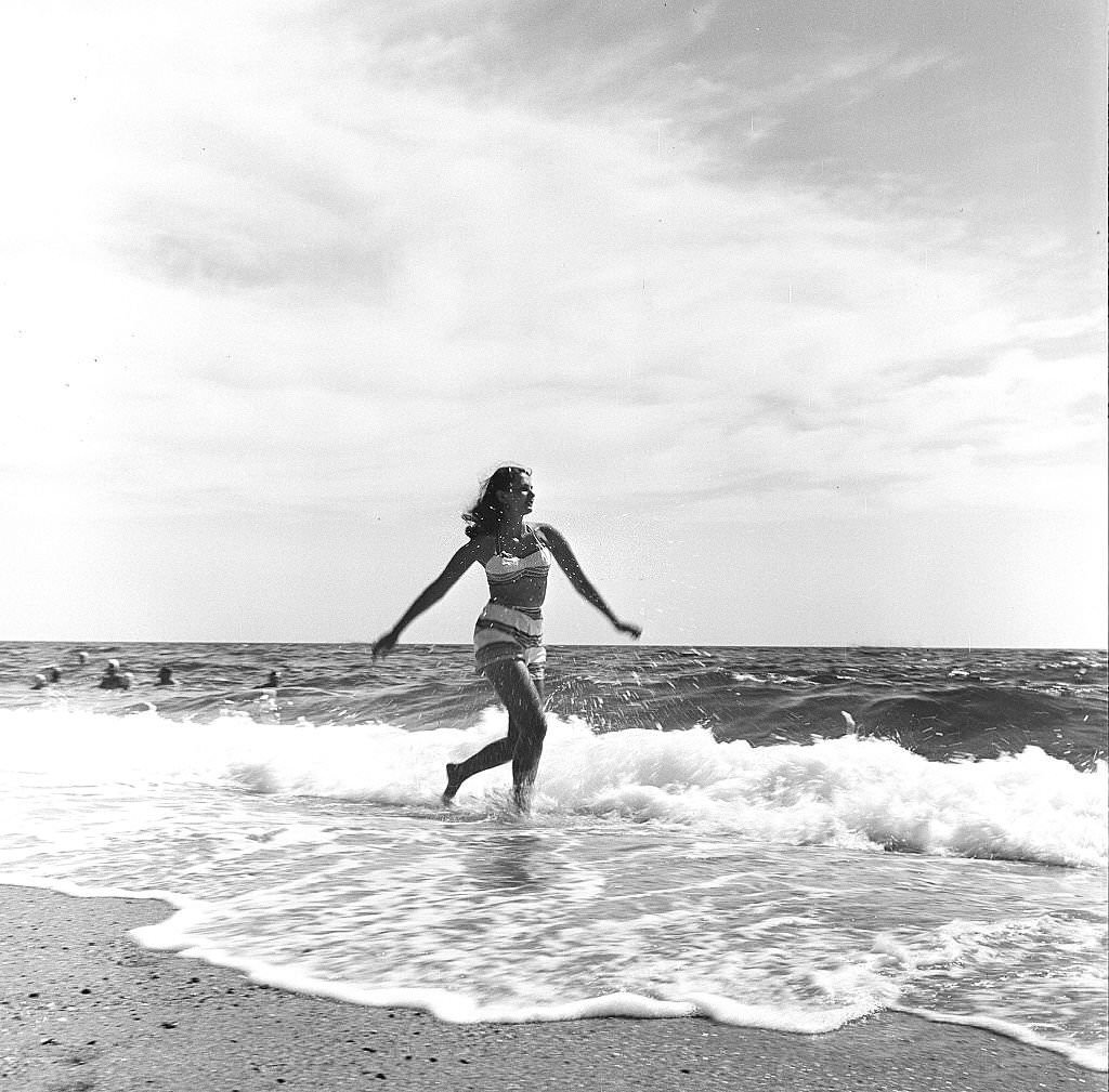 #134 A woman runs along the beach amid the surf, Provincetown, Massachusetts, 1948.