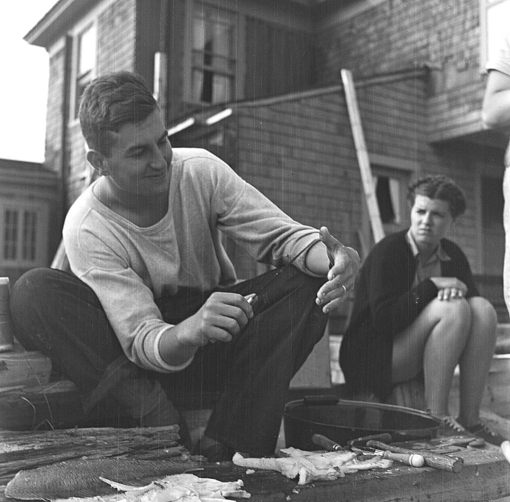 #140 A man cleans fish for a beachside cookout, Provincetown, Massachusetts, 1948.