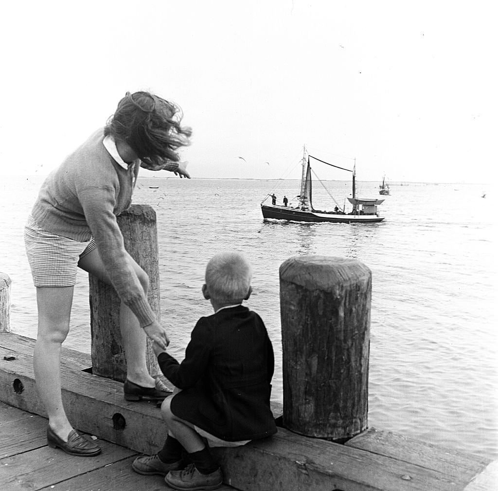 #145 A woman points out a fishing boat to her son, at the piers, Provincetown, Massachusetts, 1948.