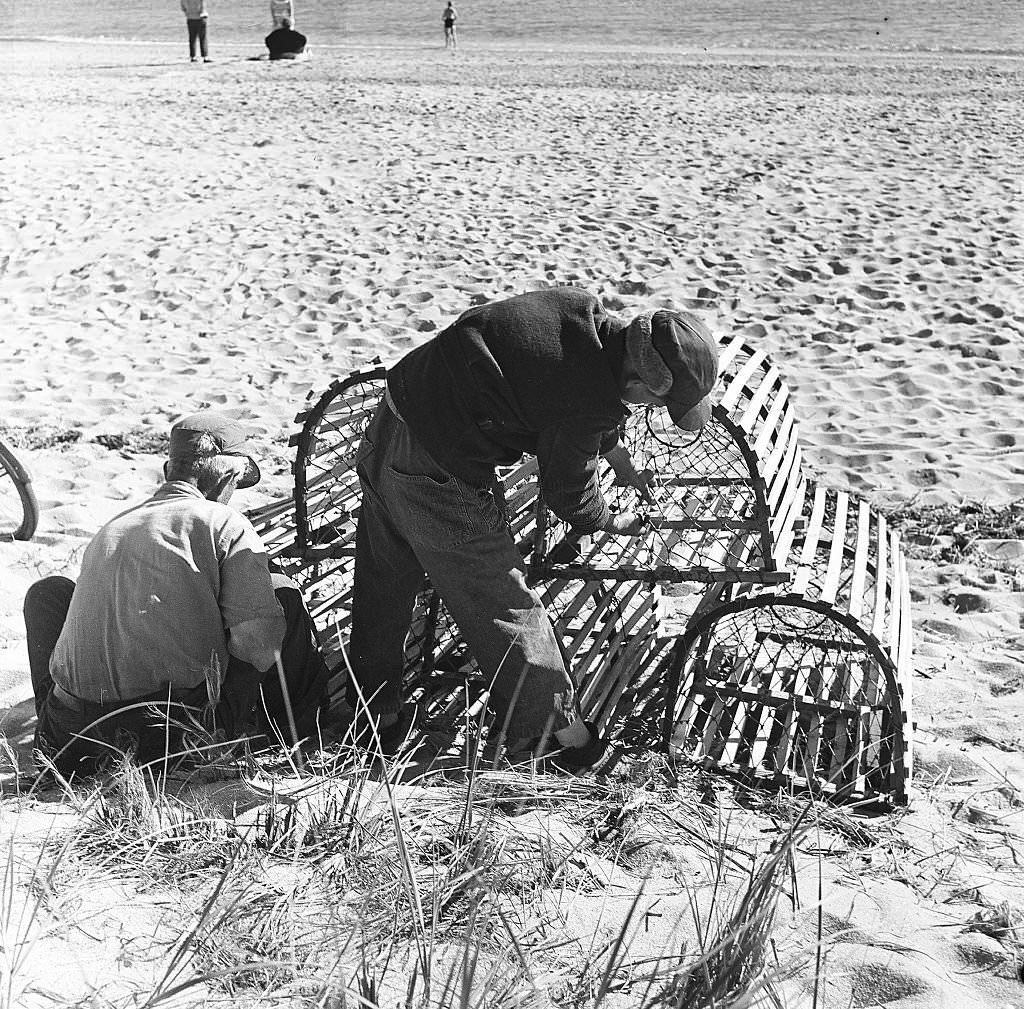 #22 Two men adjust the nets on a lobster trap on the beach on Cape Cod, Provincetown, Massachussetts, 1947.