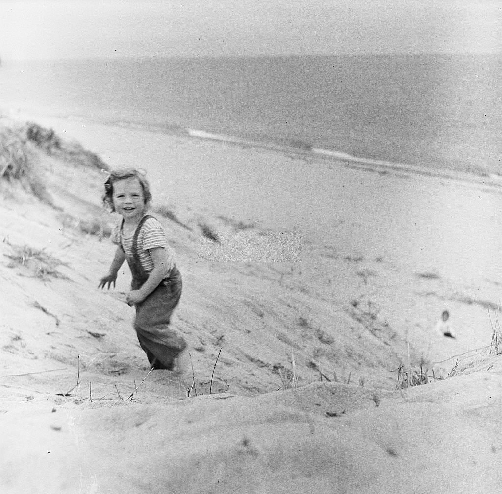 #8 A small girl smiles while walking on the beach on Cape Cod, Provincetown, Massachussetts, 1947.