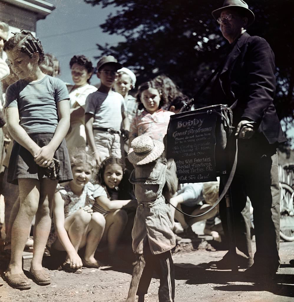#48 Bobby, a trained monkey, entertains a group of children gathered around, Provincetown, Massachusetts, 1948.