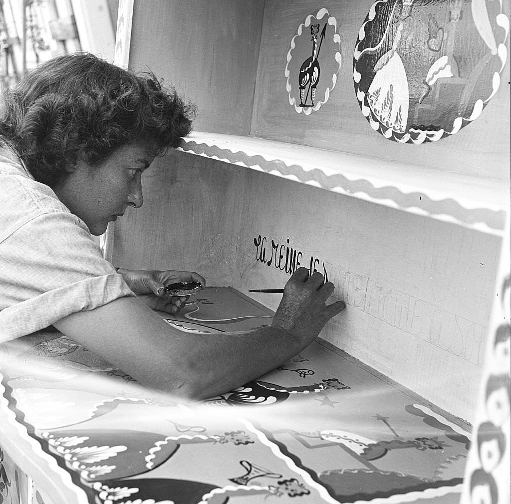 #53 An employee hand paints text onto a cabinet, at an antique shop, Provincetown, Massachusetts, 1948.