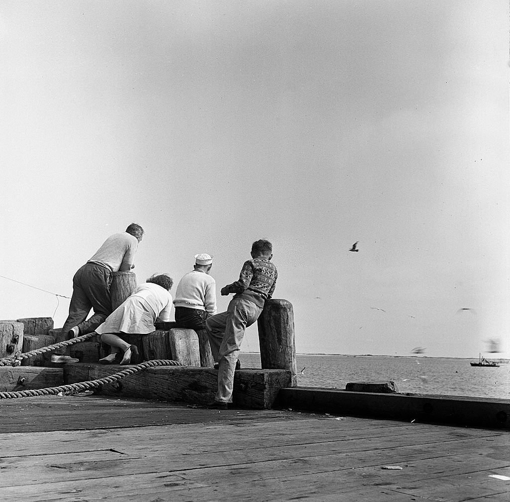 #71 A man and a woman, with two boys, look out onto the ocean from a pier on Cape Cod, Provincetown, Massachussetts, 1947.