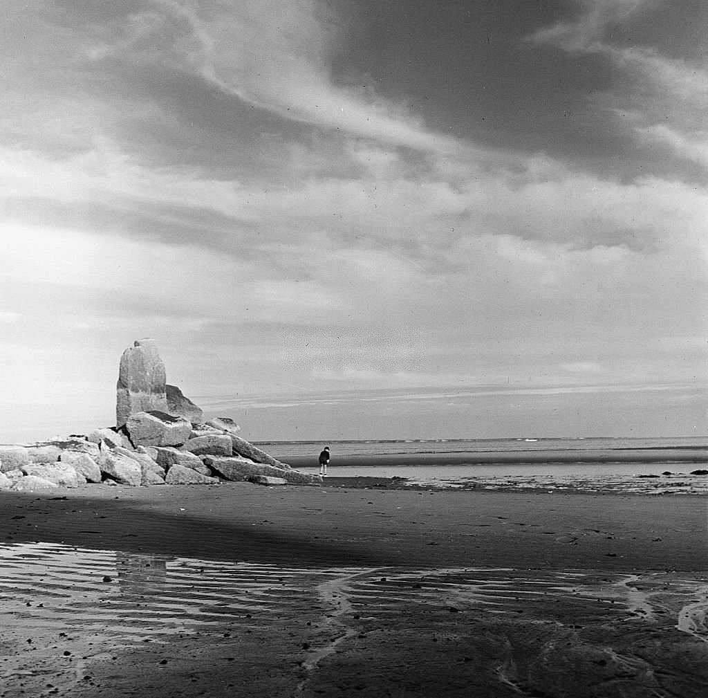 #97 A young boy looks down to examine finds in the sand on the beach, Provincetown, Massachusetts, 1948.