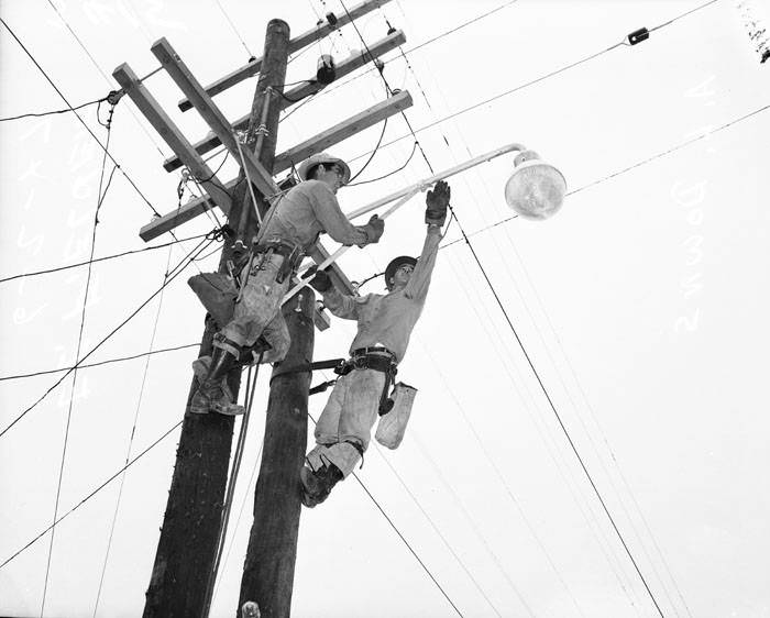#245 E.F. Fielder and A.L. Downs installing light on utility pole, 1947