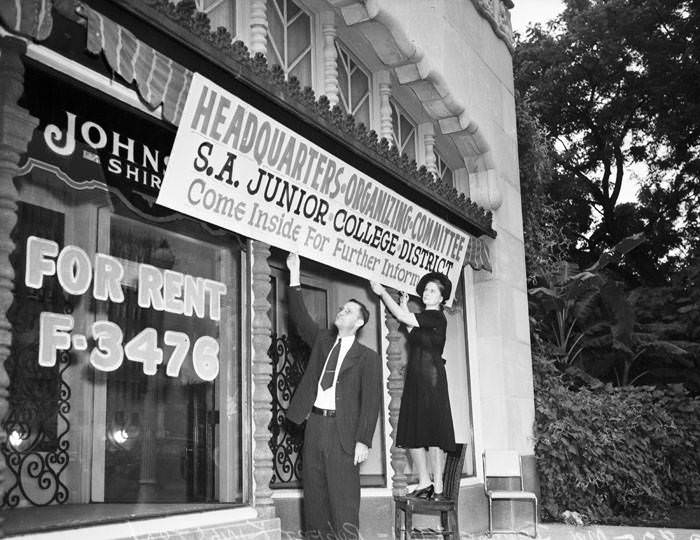 #106 Robert Kingston and Mrs. Jerome Kuhl hang banner at headquarters for San Antonio Junior College, 1941