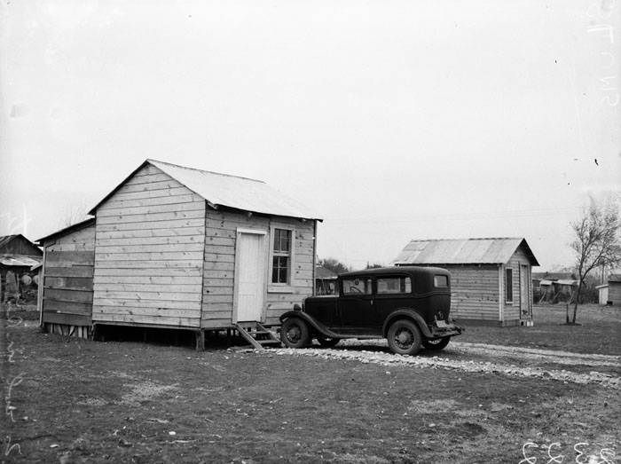 #57 Automobile parked in front of small residence, 1940