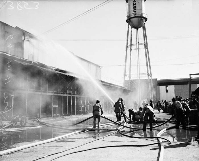 #13 Firemen, with hoses, fight fire at San Antonio Machine & Supply Company, 1949