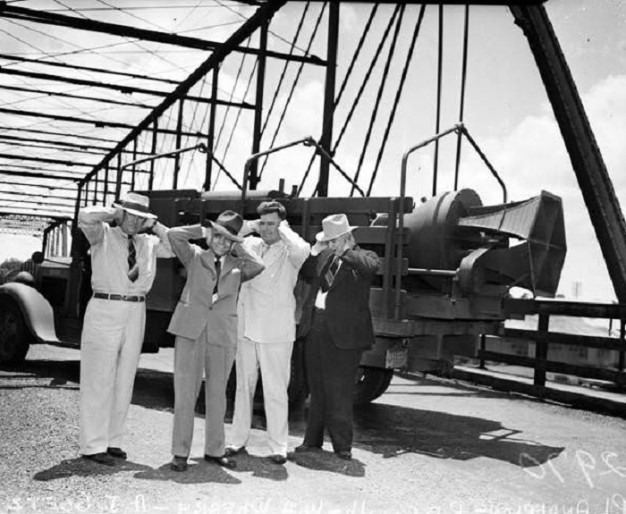 #60 Men on Hays Street bridge holding hands over ears, 1942